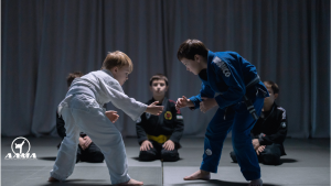 A confident young martial artist demonstrating a technique in front of classmates, showcasing martial arts leadership skills in action.