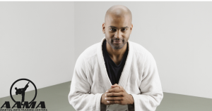 A martial artist in a traditional Kung Fu uniform demonstrating a respectful bow before stepping onto the training mat, starting his martial arts discipline.