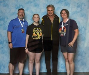 Carly with her parents and actor Martin Kove, who plays Sensei John Kreese, celebrating her martial arts goal setting and journey from student to instructor.
