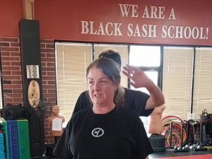Woman practicing hair grab defense during women’s self defense class Omaha